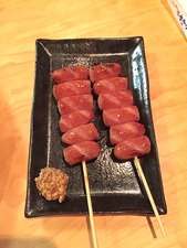 Two skewers of sausage with grainy mustard sauce at Yakitori Taisho in Clairemont