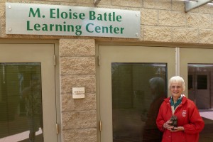Eloise Battle holds a statue of a small owl outside the learning center named in her honor. (Photo by Bill Swank)